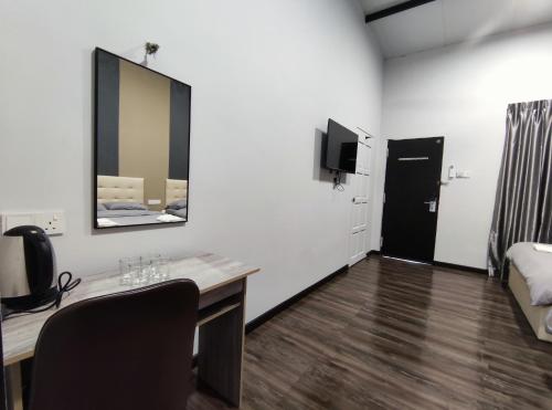 a room with a desk and a bed and a mirror at Private Room with ensuite bathroom in Bukit Bakri in Bakri