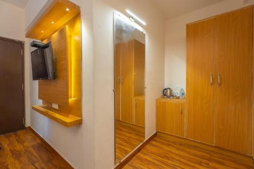 a bathroom with wooden cabinets and a television in a room at The Boho, Vagator Beach Goa Near Thalassa in Anjuna