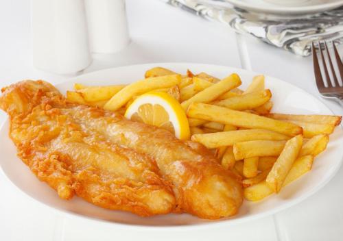 a plate of fish and french fries with a lemon at The Angel Hotel in Alton