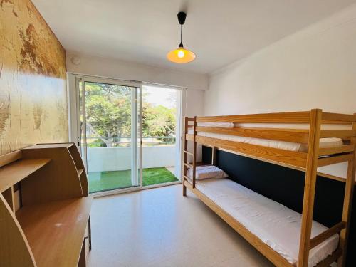 une chambre avec deux lits superposés et une fenêtre dans l'établissement Les Demoiselles, appartement emplacement idéal, à Saint-Jean-de-Monts
