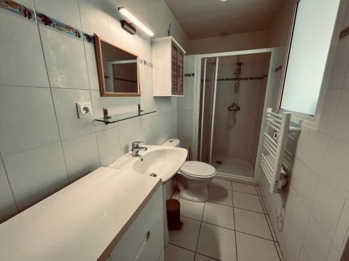 une salle de bain blanche avec un lavabo et des toilettes dans l'établissement Les Demoiselles, appartement emplacement idéal, à Saint-Jean-de-Monts
