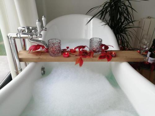 a shelf in a bath tub with candles and red bows at Casa Salitre in Boiro