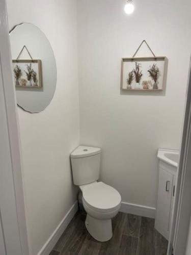 a white bathroom with a toilet and a sink at Holyhead central stay in Holyhead