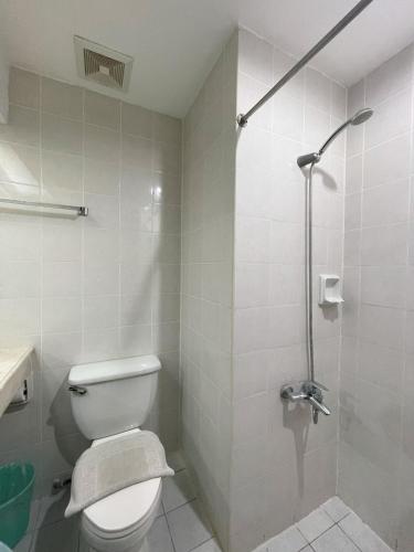 a bathroom with a toilet and a shower at Golden Peak Hotel & Suites powered by Cocotel in Cebu City