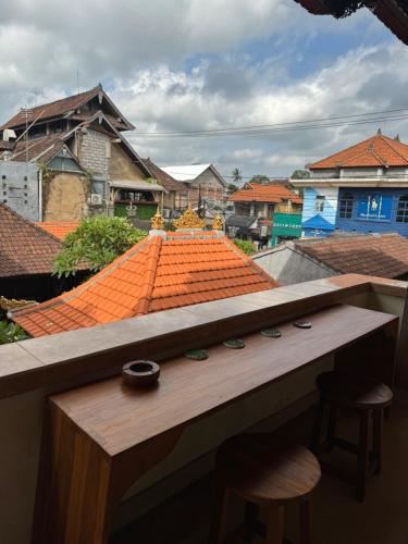 a balcony with two stools and an orange roof at Nua House in Ubud