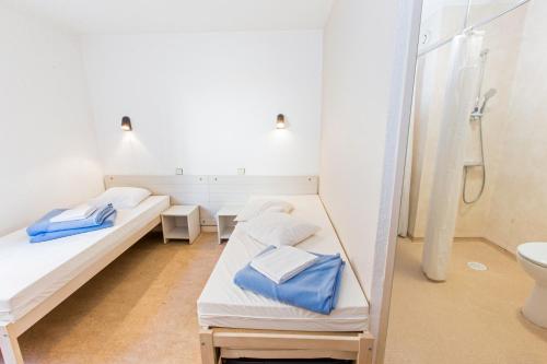 a hospital room with two beds and a shower at Auberge de Jeunesse Youth Hostel Ethic étapes Saint Malo in Saint Malo