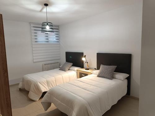 een slaapkamer met 2 bedden en een raam bij Vandelvira 2 in Baeza