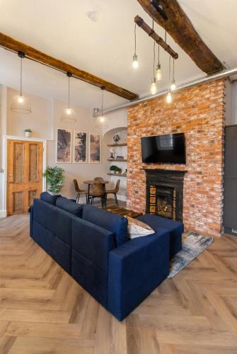 a living room with a blue couch and a fireplace at WhiskAwayStays - Shaw Mews - Apartment 3 in Worcester