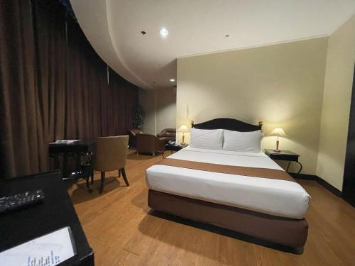 a hotel room with a bed and a desk at Golden Peak Hotel & Suites powered by Cocotel in Cebu City