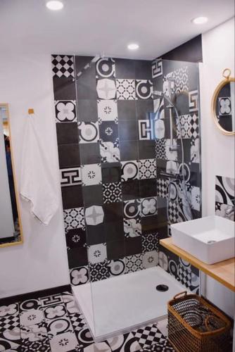 La salle de bains est pourvue d'un lavabo et de carrelage noir et blanc. dans l'établissement Maison de vacances de charmes au bord de la mer, à Saint-Brévin-les-Pins