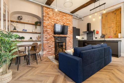 a living room with a blue couch and a fireplace at WhiskAwayStays - Shaw Street - Character city centre apartment in Worcester