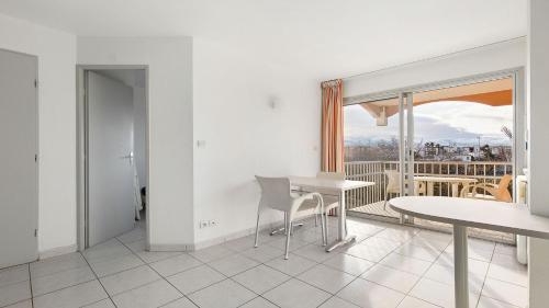 une salle à manger avec une table et une vue sur un balcon dans l'établissement PRIMAVERA 321 - Appt lumineux 4 pers, au Cap d'Agde