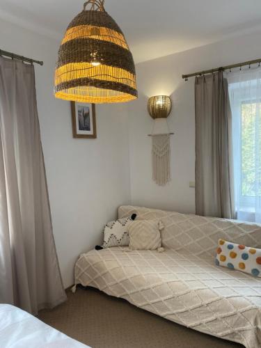 a bedroom with a bed and a chandelier at Sandomiria in Sandomierz