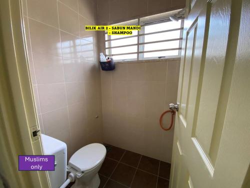 a small bathroom with a toilet and a window at Homestay Cikgu Ahmed Batu Kikir in Batu Kikir