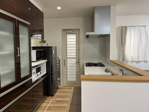 a kitchen with a black refrigerator and a counter at 湘南片瀬HOME in Fujisawa
