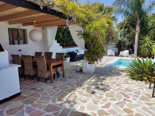 a patio with a table and chairs and a swimming pool at Finca Rayo del Sol in Alhaurín el Grande