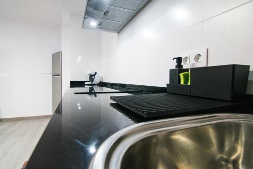 a bathroom with a black counter with a sink at Loft Centro Huelva in Huelva