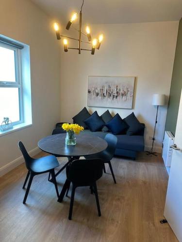 Dublin City Centre Apartment في دبلن: غرفة معيشة مع طاولة وأريكة زرقاء