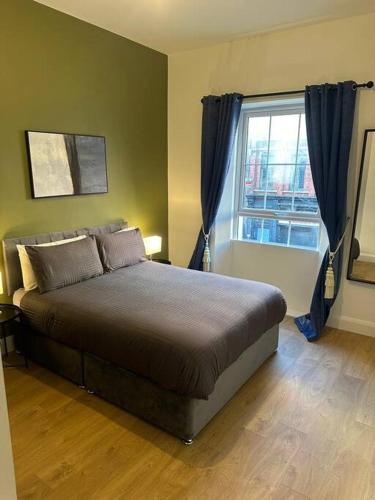 Dublin City Centre Apartment في دبلن: غرفة نوم بسرير كبير ونافذة