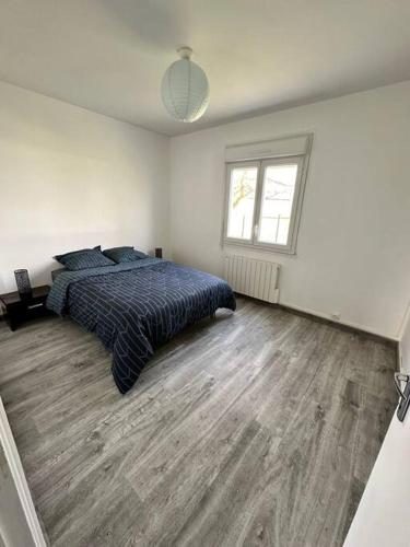 a white bedroom with a bed and a window at Petite maison sur aérodrome in Cosne-Cours-sur-Loire