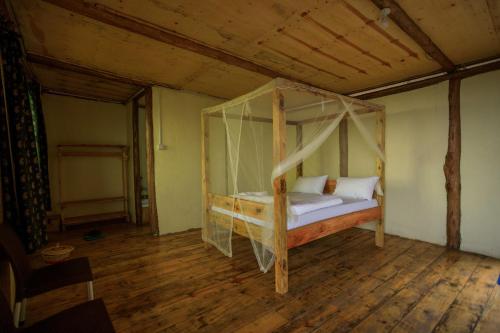 ein Schlafzimmer mit einem Himmelbett in einem Zimmer in der Unterkunft lake mwamba lodge in Kasenda