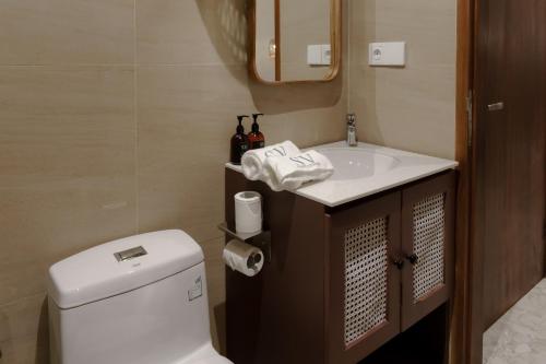 a bathroom with a toilet and a sink at Sunny Cuddles in Canggu