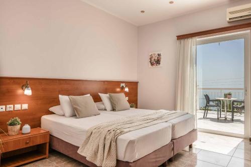 a bedroom with a large bed and a balcony at Villa Marita in Spathíon