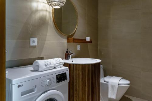 a bathroom with a sink and a washing machine at Sunny Cuddles in Canggu