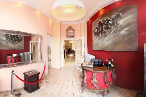 a hallway with a red wall with a horse painting at Hotel Excellent in Lübeck