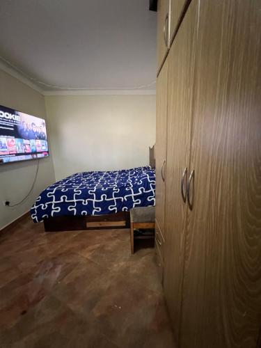 1 dormitorio con 1 cama y armario grande en MD comfort homes, en Kampala