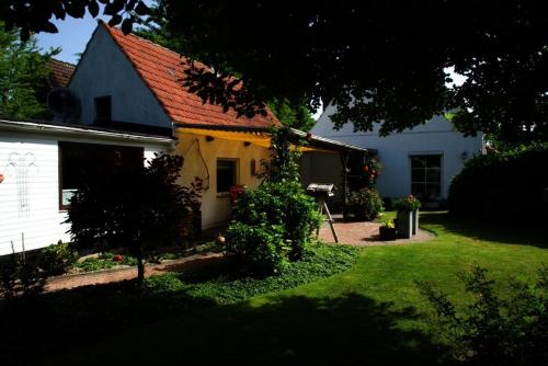 una casa bianca con tetto rosso e cortile di Gemütliches Haus - traumhafter großer Garten 
