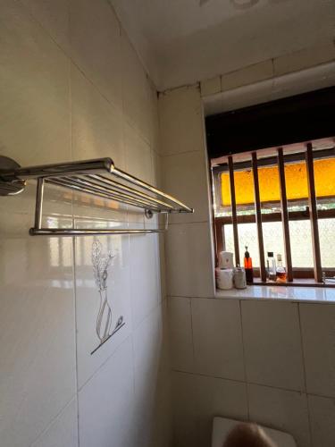 a bathroom with a window and a towel rack on the wall at MD comfort homes in Kampala