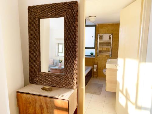 a bathroom with a mirror on a wooden dresser at Annie's Boutique Apartment in Jerusalem in Jerusalem