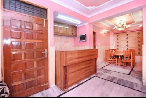een kamer met 2 deuren en een eetkamer met een tafel bij Hotel Hill view in Shimla
