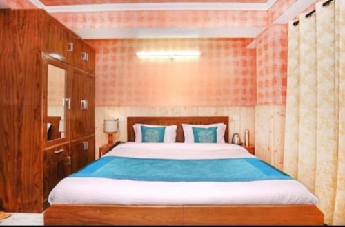 een slaapkamer met een groot bed met blauwe lakens bij Hotel Hill view in Shimla