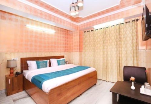 een slaapkamer met een bed, een bureau en een televisie bij Hotel Hill view in Shimla
