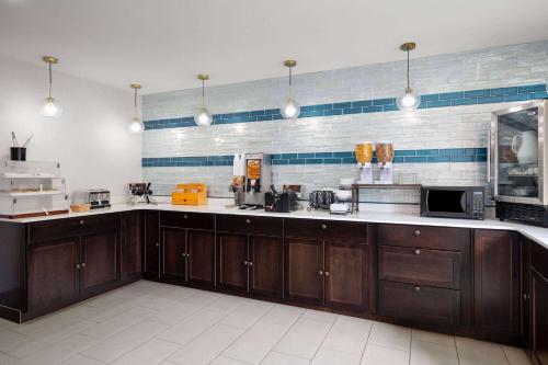 a large kitchen with wooden cabinets and appliances at La Quinta Inn by Wyndham Indianapolis Airport Executive Dr in Indianapolis