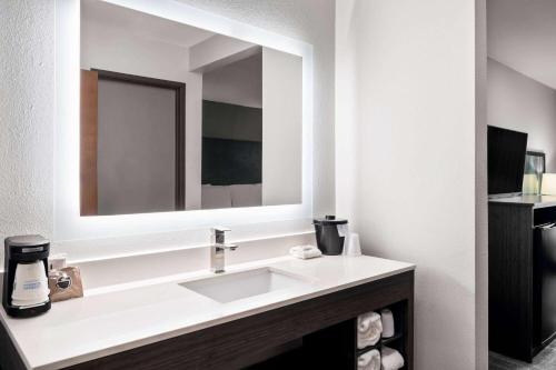 a bathroom with a sink and a mirror at La Quinta Inn by Wyndham Indianapolis Airport Executive Dr in Indianapolis
