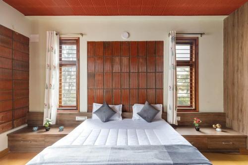 um quarto com uma cama grande e 2 janelas em Zenith Edge Villa by JadeCaps 3BHK Duplex Wifi em Bangalore