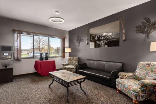 a living room with a couch and chairs and a table at Travelodge by Wyndham Brandon in Brandon