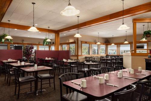 un comedor con mesas, sillas y ventanas en Travelodge by Wyndham Brandon, en Brandon