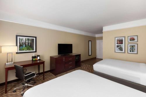 a hotel room with a bed and a desk with a computer at La Quinta by Wyndham Houma in Houma