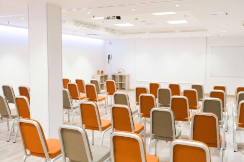 an empty room with orange and white chairs at Radisson Blu Elizabete Hotel, Riga in Rīga