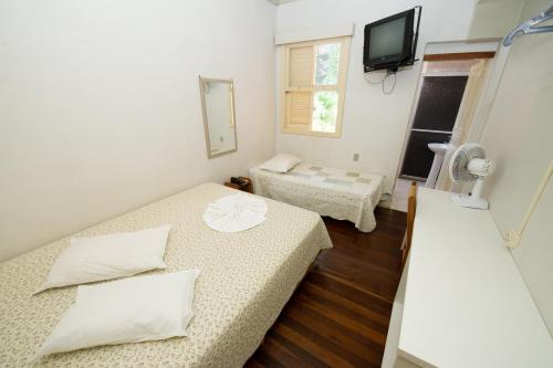 ファホウピーリャにあるAdoro Hotelのベッド2台とテレビのある小さな部屋