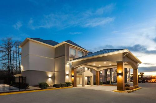 a large white building with a lit up driveway at La Quinta by Wyndham Houma in Houma