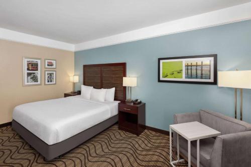 a hotel room with a bed and a couch at La Quinta by Wyndham Houma in Houma