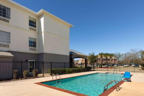 a swimming pool in front of a building at La Quinta by Wyndham Houma in Houma