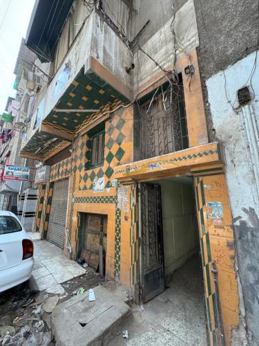 an old building with doors and a car parked outside at غرفه خاصه لك جديده وفرش جديد ومميز بها سريرين وتلفزيون in Mansoura
