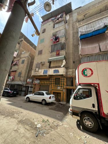 un camion bianco parcheggiato di fronte a un edificio di غرفه خاصه لك جديده وفرش جديد ومميز بها سريرين وتلفزيون a Mansoura
