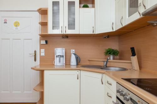 a kitchen with white cabinets and a sink at Charming Apartment Located near the Promenade in Świnoujście by Renters in Świnoujście